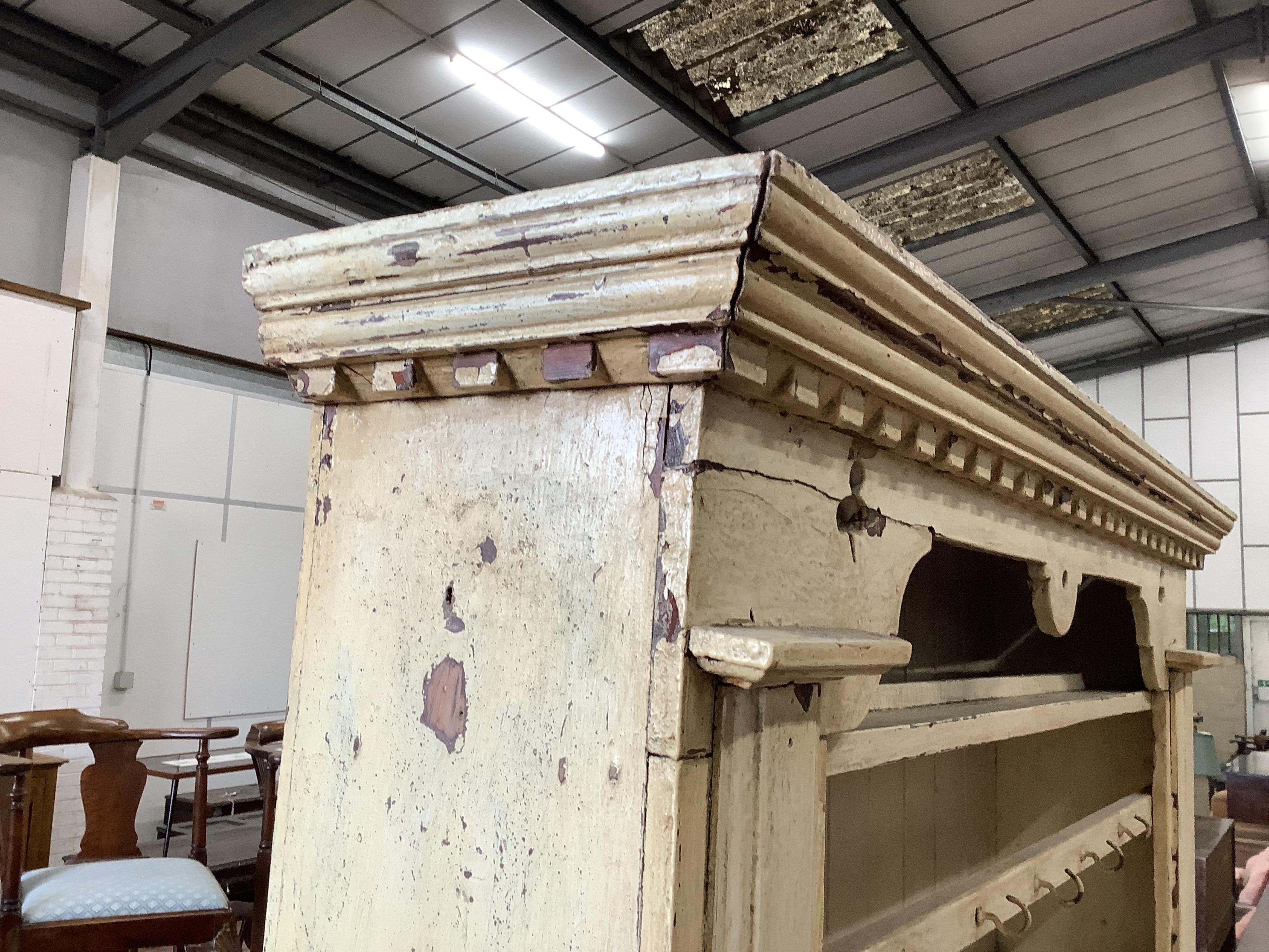 An early 19th century Irish painted pine dresser with boarded rack, width 126cm, depth 49cm, height 210cm. Condition - fair